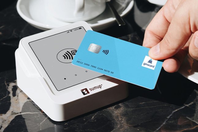 Girocard wird kontaktlos an einem SumUp-Zahlterminal gehalten