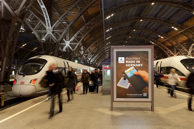 Werbeplakat Bezahlen made in Germany auf einem Bahnhofsbahnsteig