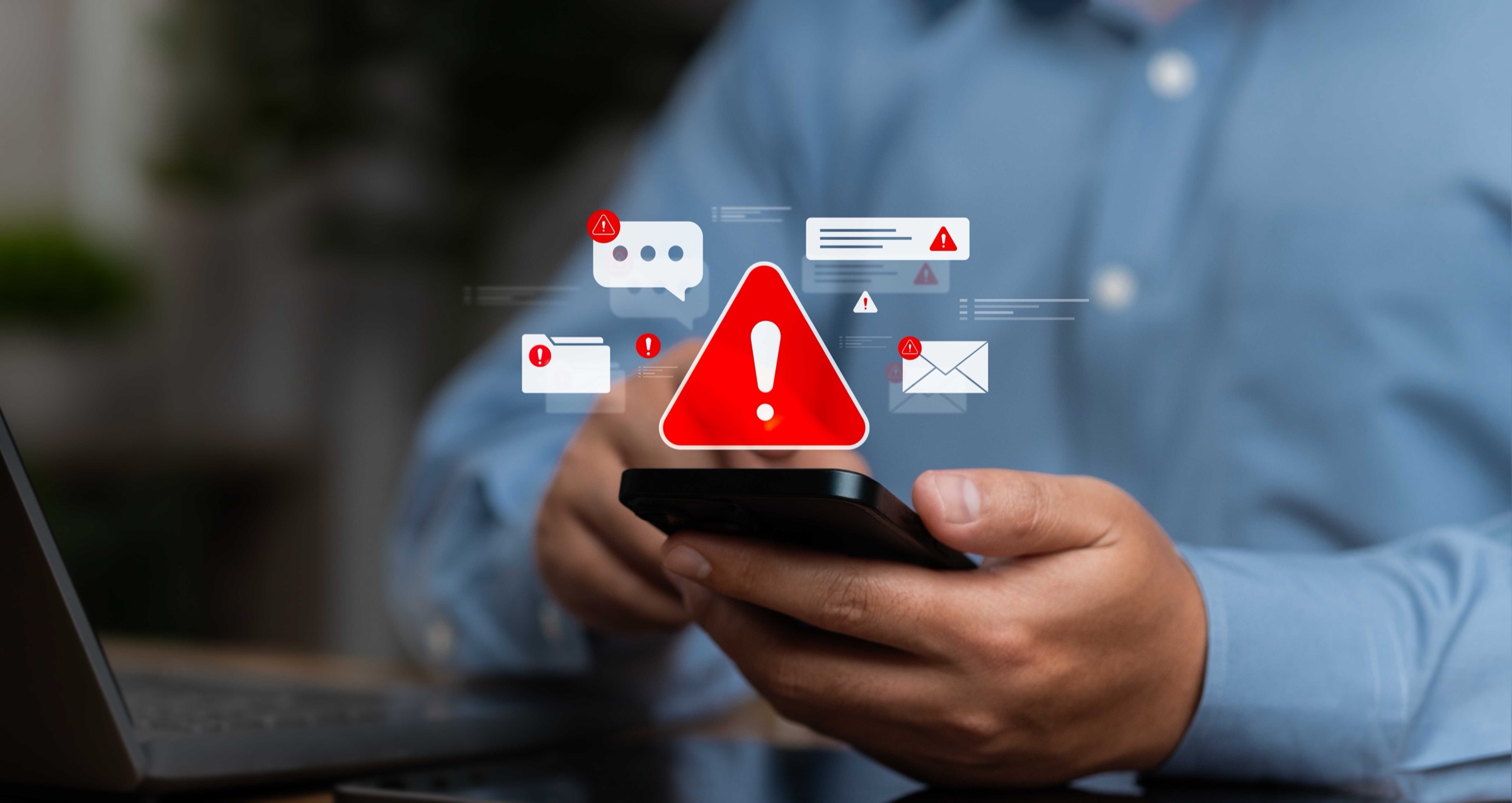Eine Person hält ein Smartphone in der Hand, darüber schweben ein rotes Warndreieck und Nachrichtensymbole mit Warnhinweisen